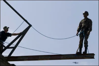 En formation, voici la situation : Tu es perché à 20 mètres de haut et tu te trouves sur une planche attaché à un harnais. Un instructeur te demande de le détacher. Que fais-tu ?