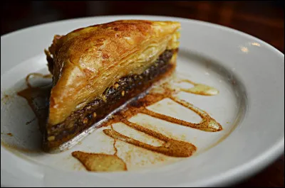 Le baklava est un délicieux dessert qui vient du Moyen-Orient. Quel ingrédient donnant beaucoup de goût à cette pâtisserie se trouve à l'intérieur ?